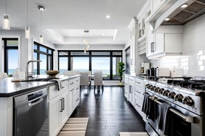 A modern kitchen with a view of the ocean, stainless steel appliances, and a large island.