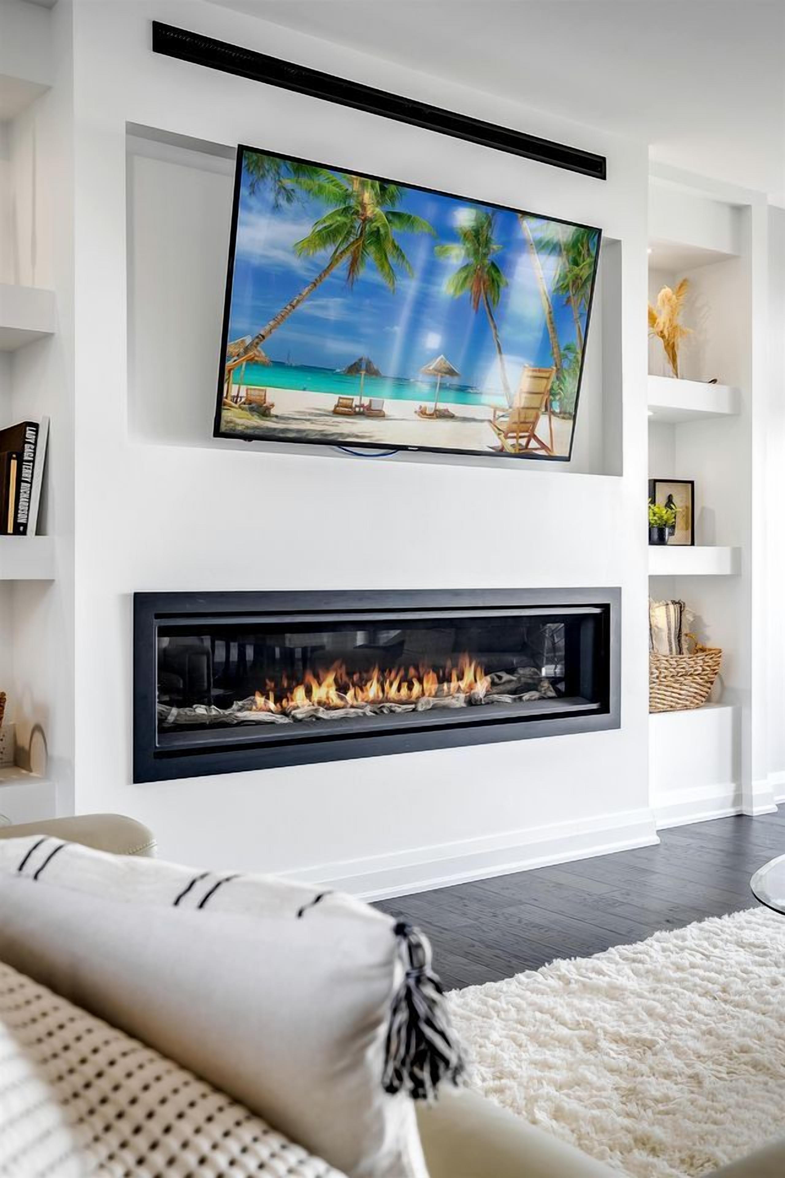 Ein modernes Wohnzimmer mit einem Flachbildfernseher über einem Kamin, einer Couch und einem flauschigen Teppich.