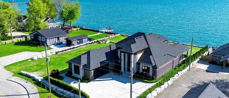 A residential area with houses, a clear blue sky, and a view of the sea.