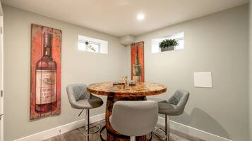 Un coin repas avec une table ronde, deux chaises et un grand tableau accroché au mur.