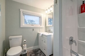 Une salle de bain avec des toilettes, un lavabo et une fenêtre.