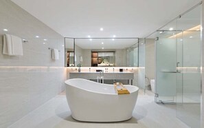 A modern bathroom with a freestanding bathtub, a glass shower enclosure, and a vanity with a mirror. - Nobel Longevity and Wellness Retreat (Bangkok)