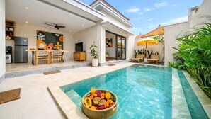 A modern house with a swimming pool, a dining area, and a kitchen. - Lekatika Villa (Kerobokan)