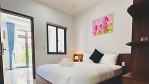 Una habitación de hotel con una cama grande, una mesita de noche, una lámpara, un cuadro y vistas a través de una ventana.