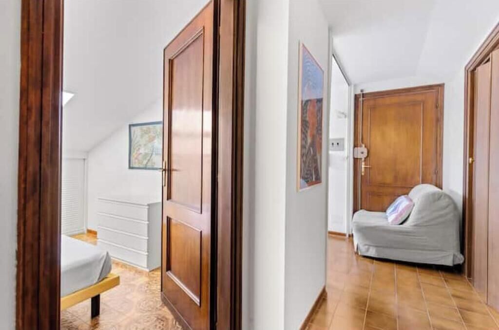 Ein Schlafzimmer mit einem Bett, einem Holzschrank und einem kleinen Nachttisch.