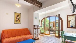 Une pièce comprenant un canapé, un banc, une table et des chaises, avec vue sur l’extérieur.