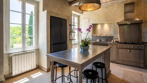 A kitchen with a central island, a stove, and a refrigerator. - Domaine de la Rose Comtesse - Luxe (Ventabren)