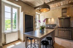 A kitchen with a central island, a stove, and a refrigerator. - Domaine de la Rose Comtesse - Luxe (Ventabren)
