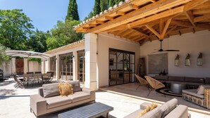 An outdoor patio area with a wooden pergola, a sofa, a dining table, and chairs. - Domaine de la Rose Comtesse - Luxe (Ventabren)