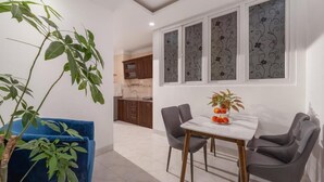 A dining area with a table, chairs, and a potted plant. - Miami Beach Hotel & Apartment (Da Nang)