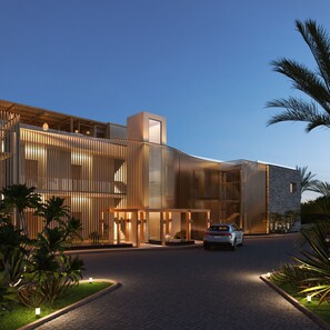 A modern building with a curved facade, a car parked in front, and a well-lit entrance. - Pefkian Ethos Hotel & Suites (Rhodes)