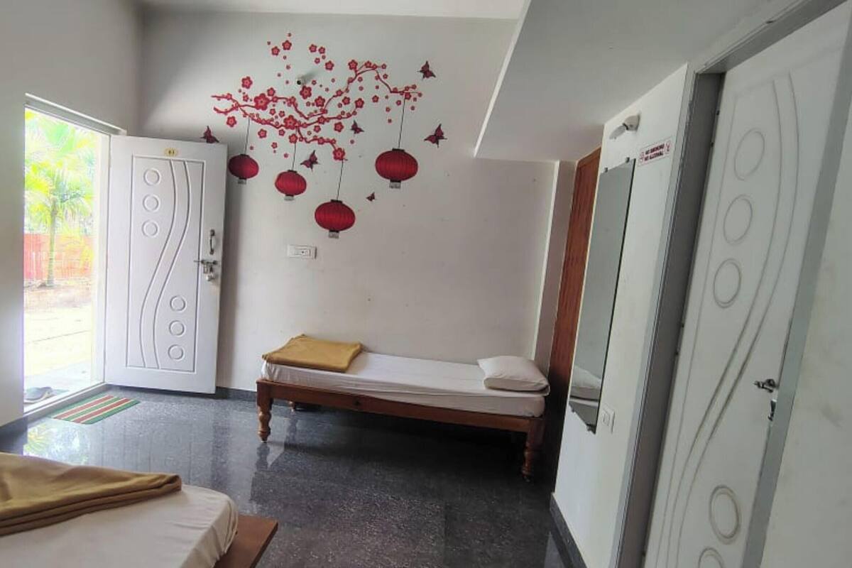 A hotel room with a bed, a bedside table, a wall-mounted decoration, and a door.