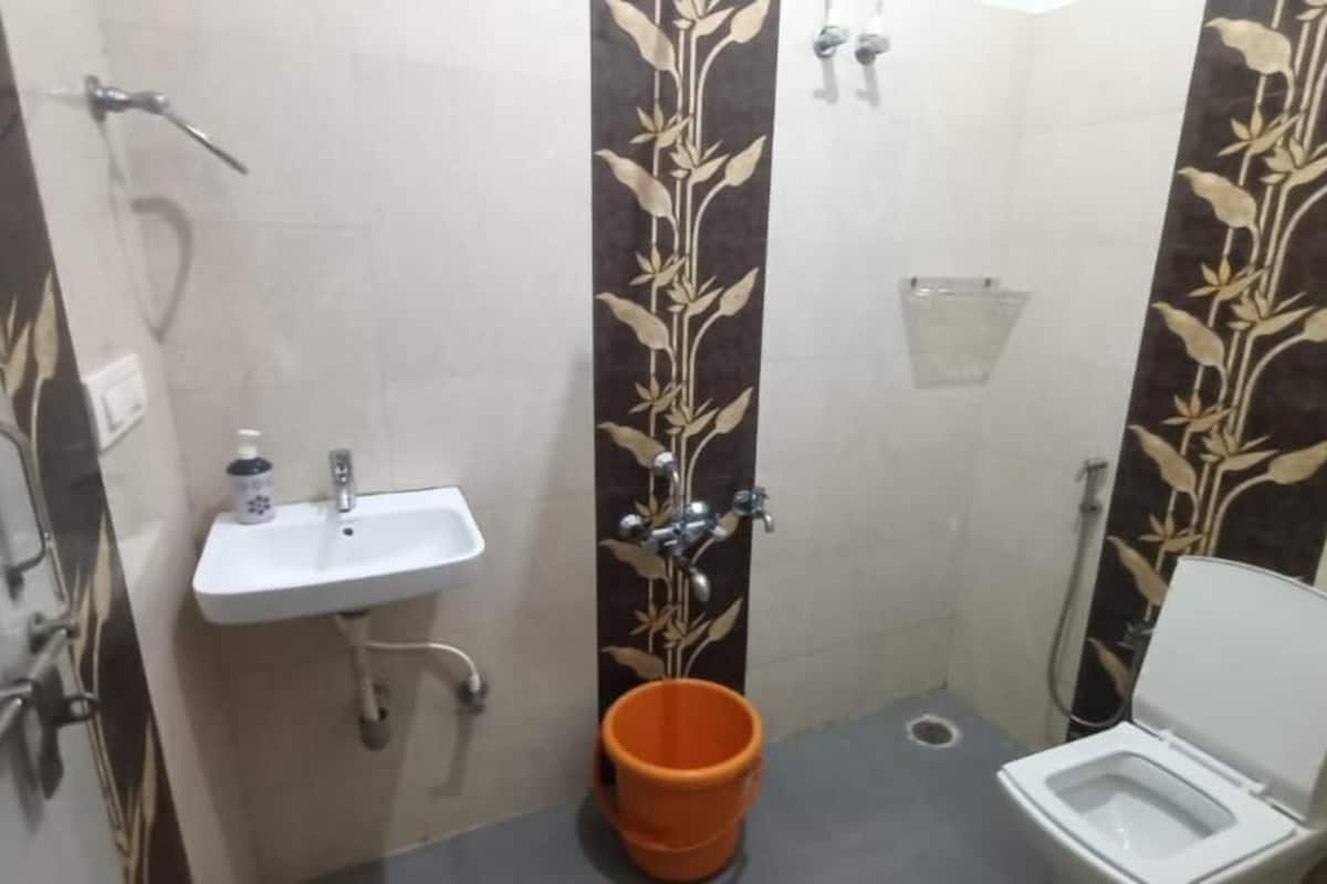 A small bathroom with a white sink, a toilet, and a shower.