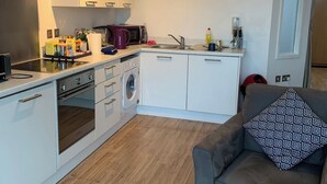 Cocina pequeña equipada con microondas, tostadora y lavabo.