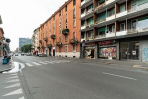 Eine Straße mit Gebäuden, einem Fußgängerüberweg und einem Geschäft mit einer Schaufensterschild.