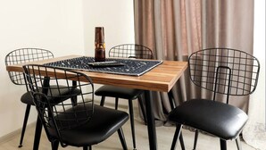 A dining area with a wooden table, black chairs, a woven placemat, and a decorative vase.