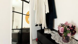 A modern room with a black dresser, a mirror, and a white wall.