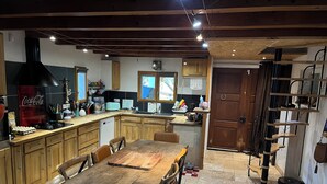 Uma cozinha ampla com armários de madeira, uma mesa de jantar e um fogão grande.