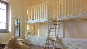 A room with two bunk beds, a ladder, a small table, and a bean bag chair. - 100% Authentic Tuscany: A Great Villa in the Countryside for Families and Groups (Toscana)