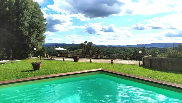 A swimming pool with a view of a garden and distant mountains. - 100% Authentic Tuscany: A Great Villa in the Countryside for Families and Groups (Toscana)