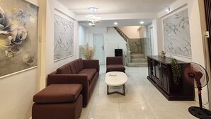 Uma sala de estar ampla com sofá, mesa de centro e ventilador.
