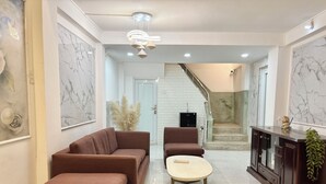 Uma sala de estar moderna com um sofá marrom, uma mesa de centro redonda e um armário de madeira escura.