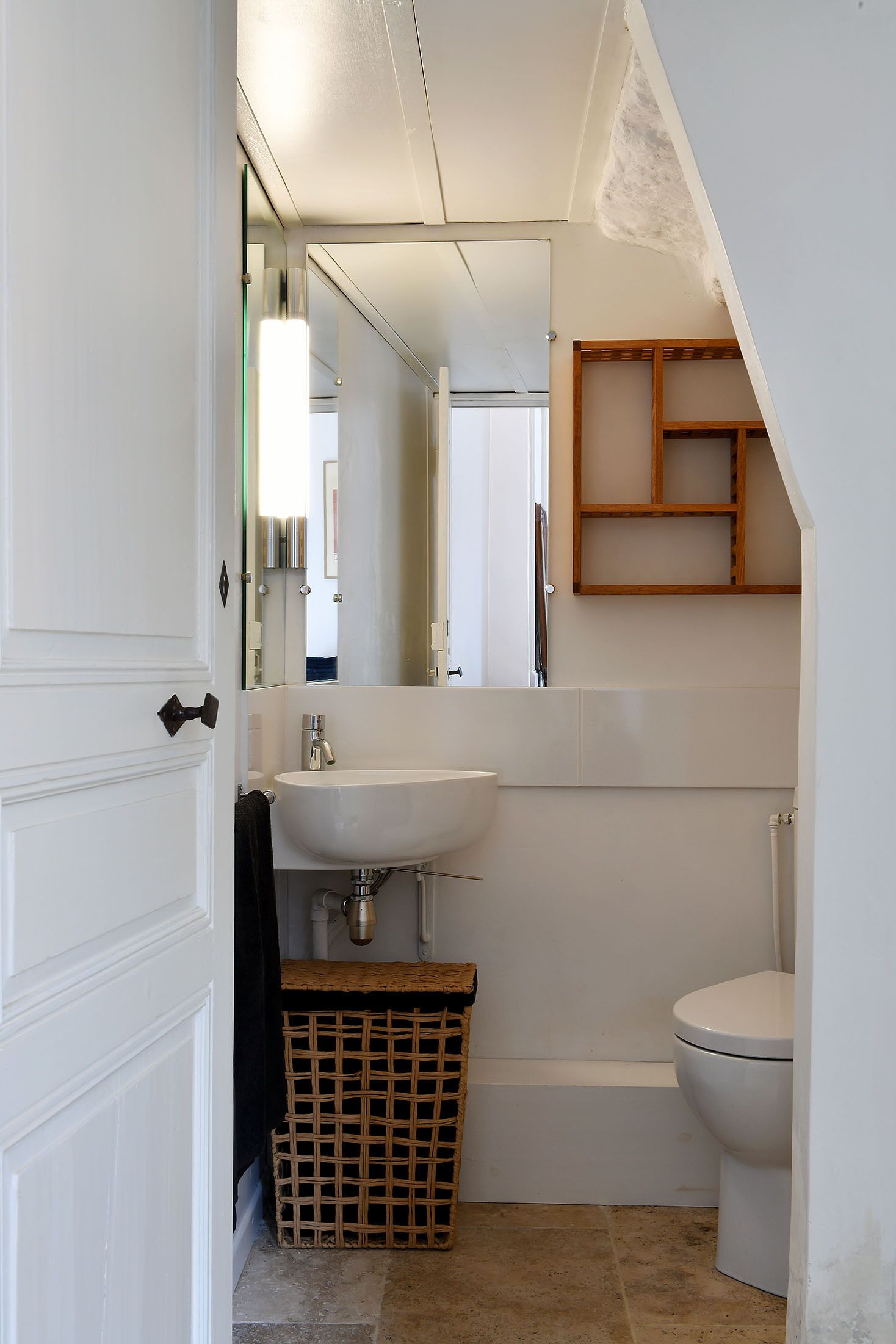 A compact bathroom with a white sink, a toilet, and a mirror.