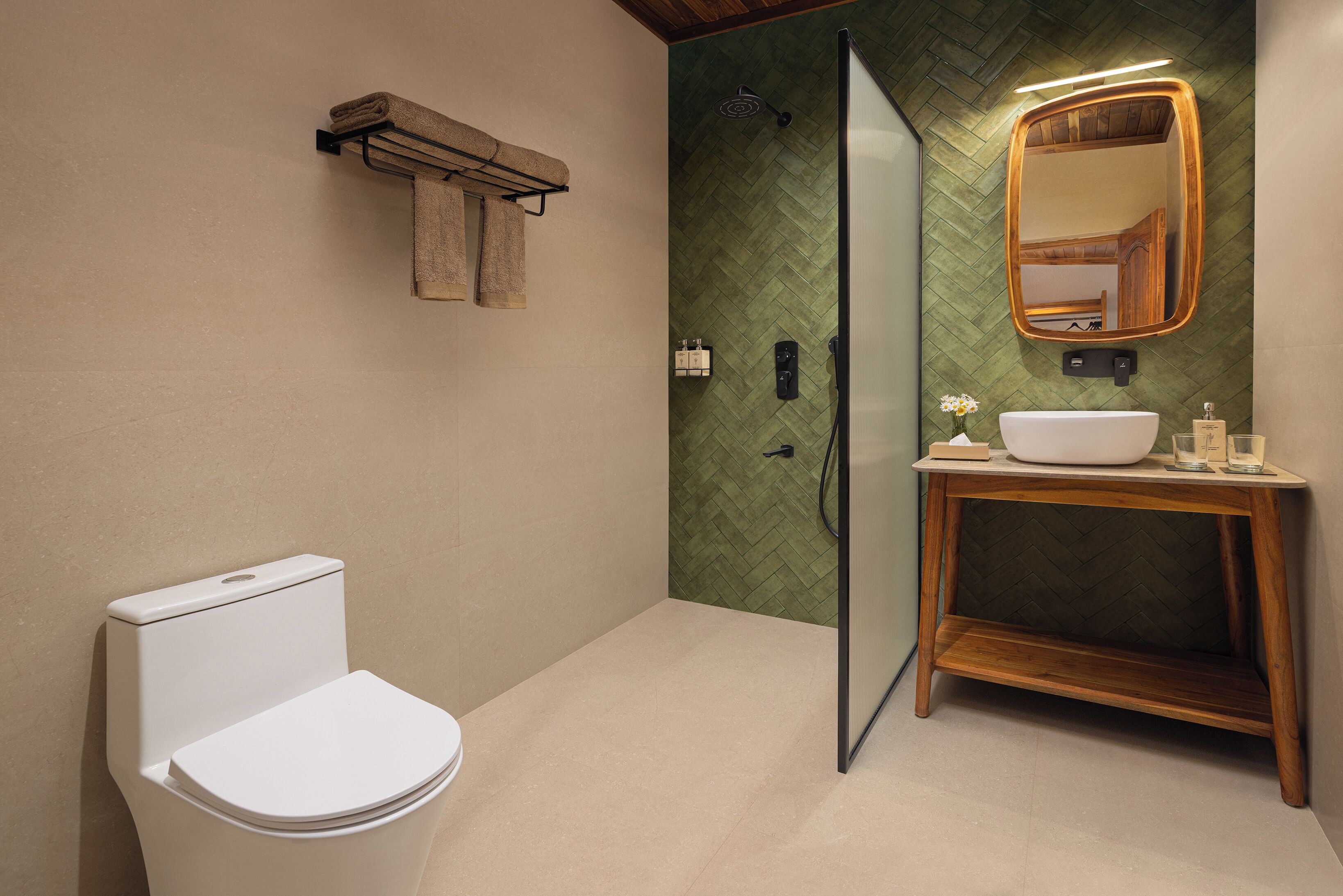 A modern bathroom with a toilet, a sink, a mirror, and a shower.