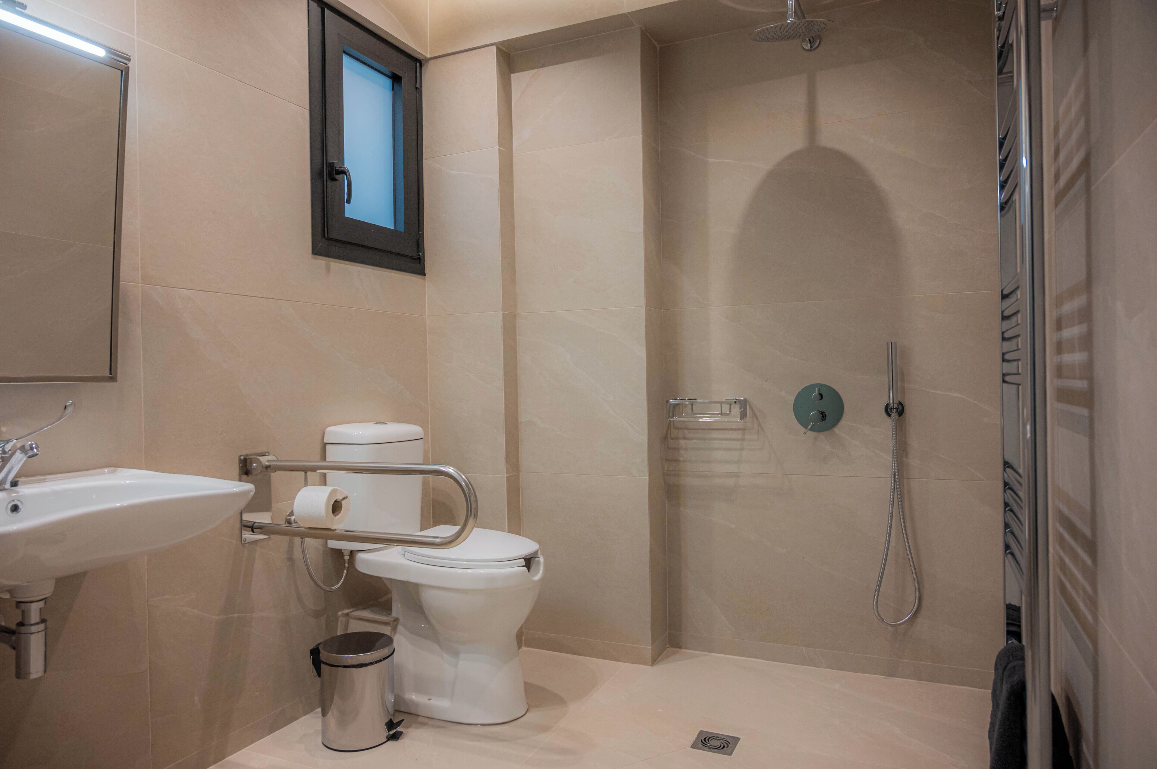 A modern bathroom with a sink, toilet, and shower.
