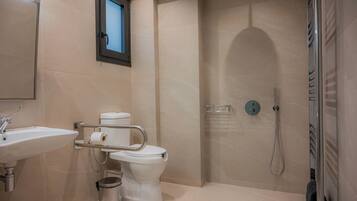 Un baño moderno con lavamanos, inodoro y ducha.