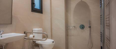A modern bathroom with a sink, toilet, and shower.