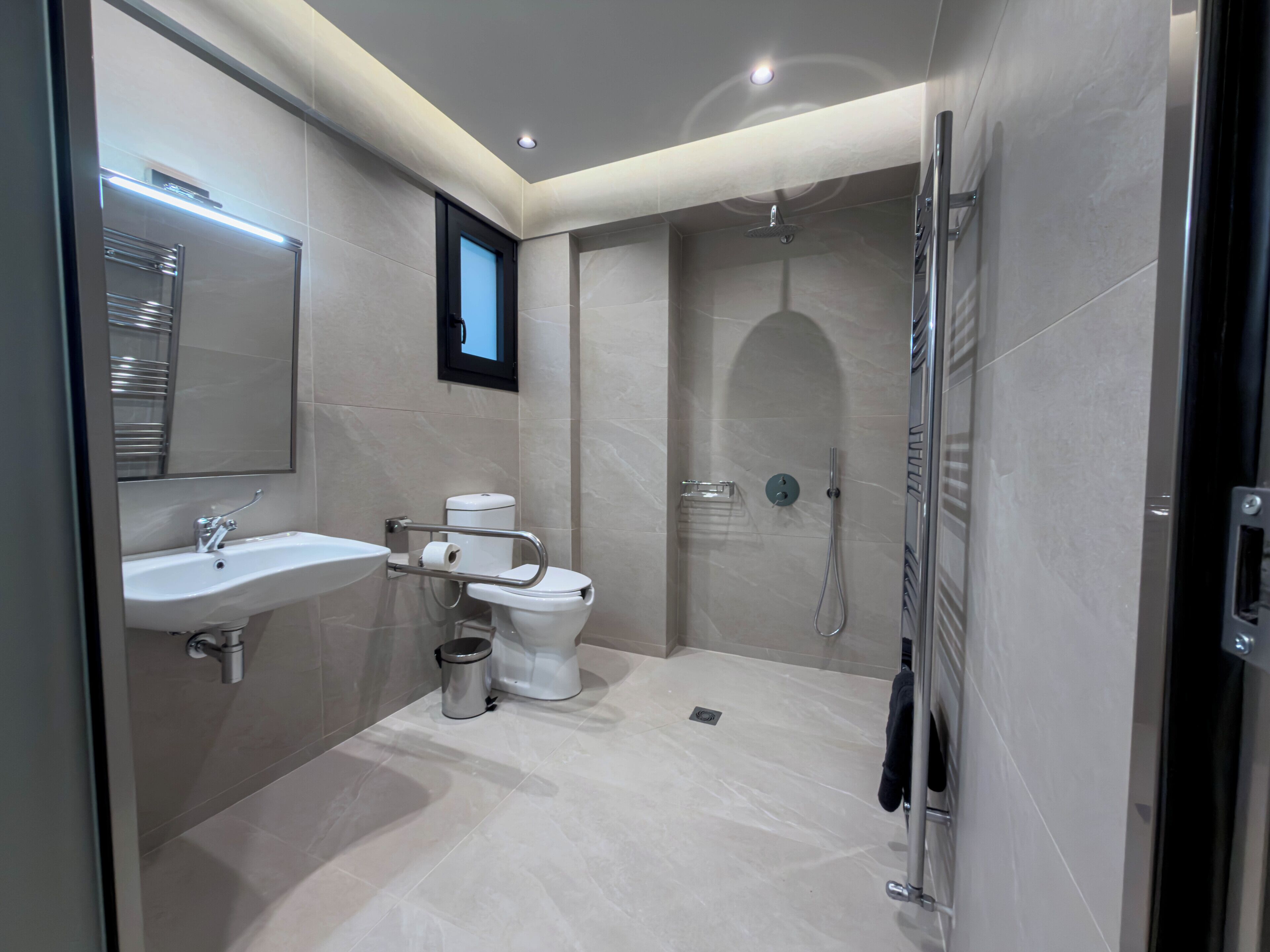 A modern bathroom with a sink, toilet, and shower.