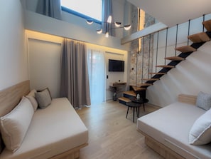 A modern hotel room with a staircase, two beds, a TV, and a small table.