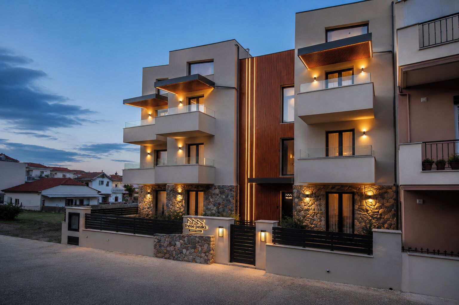 Un edificio residencial de varios pisos con balcones, detalles de piedra e iluminación cálida.