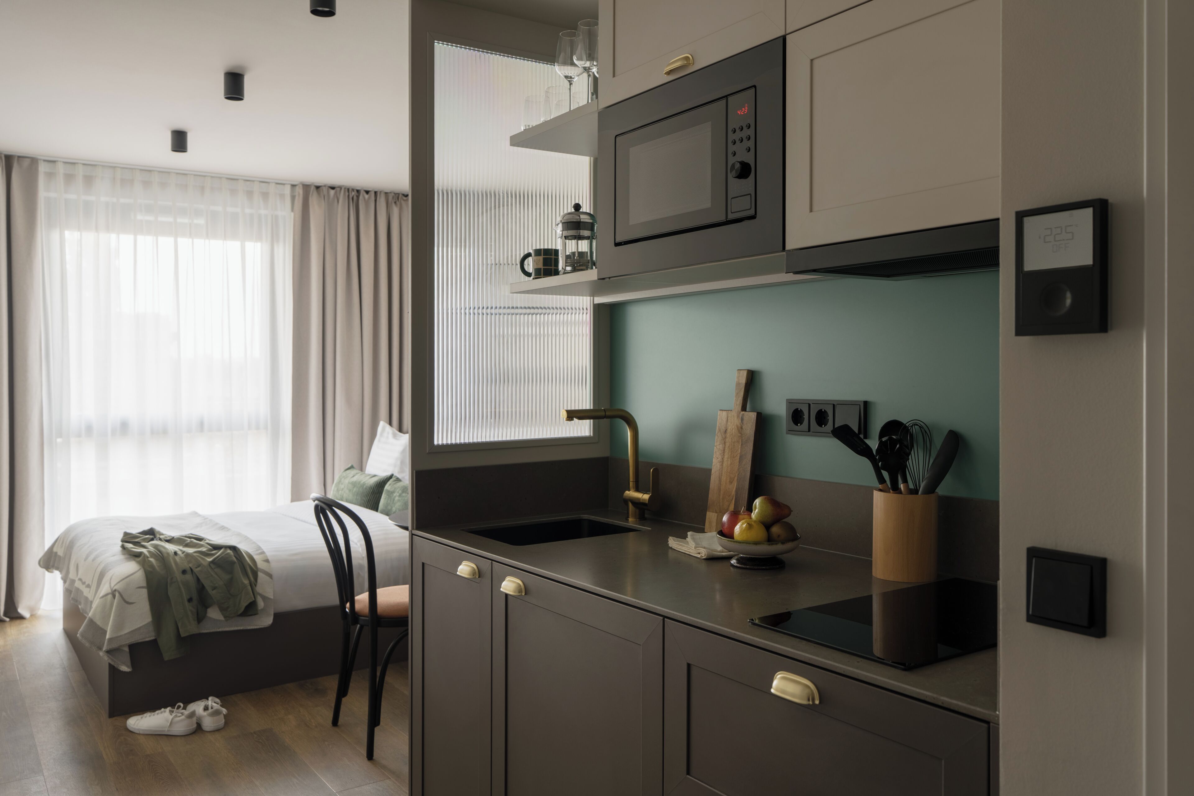 A modern kitchen with a built-in microwave, a sink, and a fruit bowl.