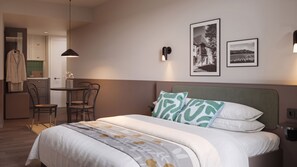 Una habitación de hotel con cama, escritorio, sillas y zona de comedor.