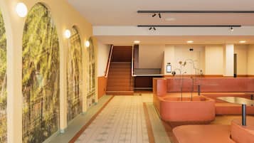 A modern interior with a staircase, a reception desk, and a seating area.