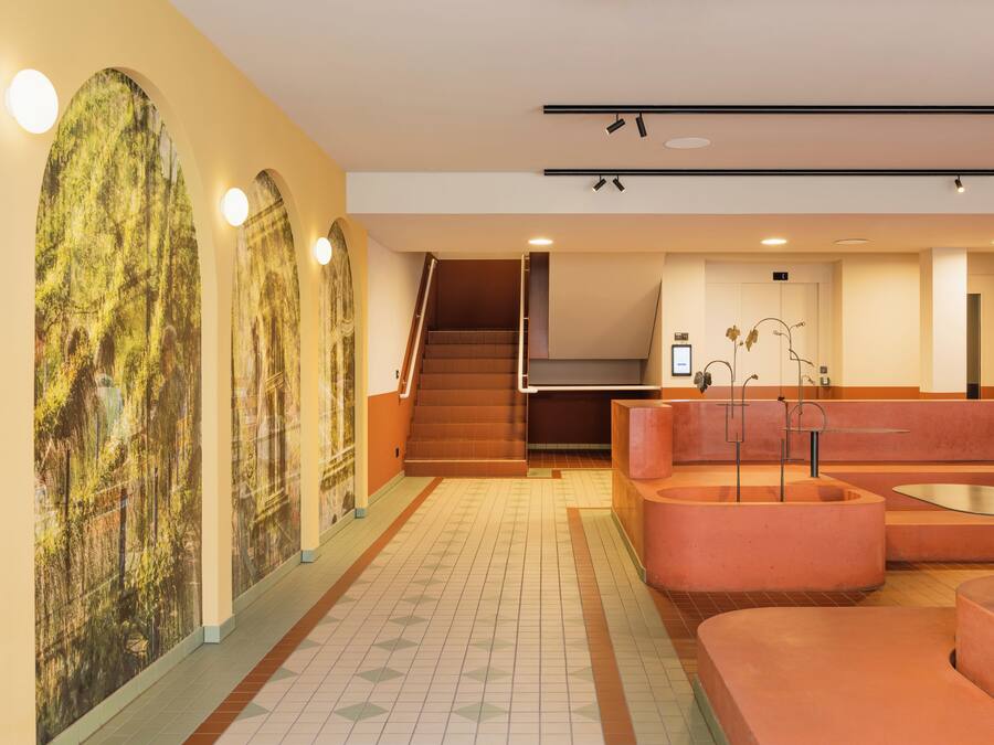 Un intérieur moderne comprenant un escalier, un comptoir d’accueil et un espace salon.