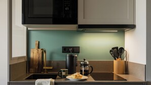 A modern kitchen with a microwave, coffee maker, and a plate of food. - Bob W Vienna Döbling (Vienna)