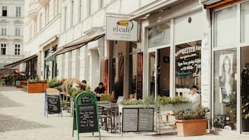 A café with outdoor seating, a signboard, and a menu board.