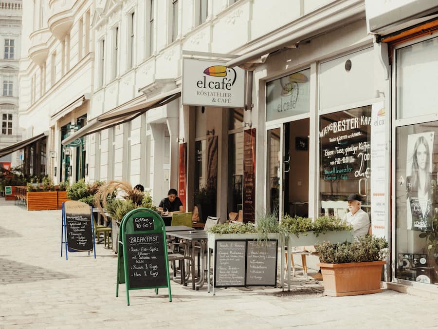 Un café con terraza, un letrero y un tablero de menú.