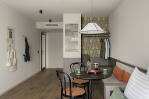 A modern dining area with a round table, chairs, a coffee maker, and a hanging lamp. - Bob W Vienna Döbling (Vienna)