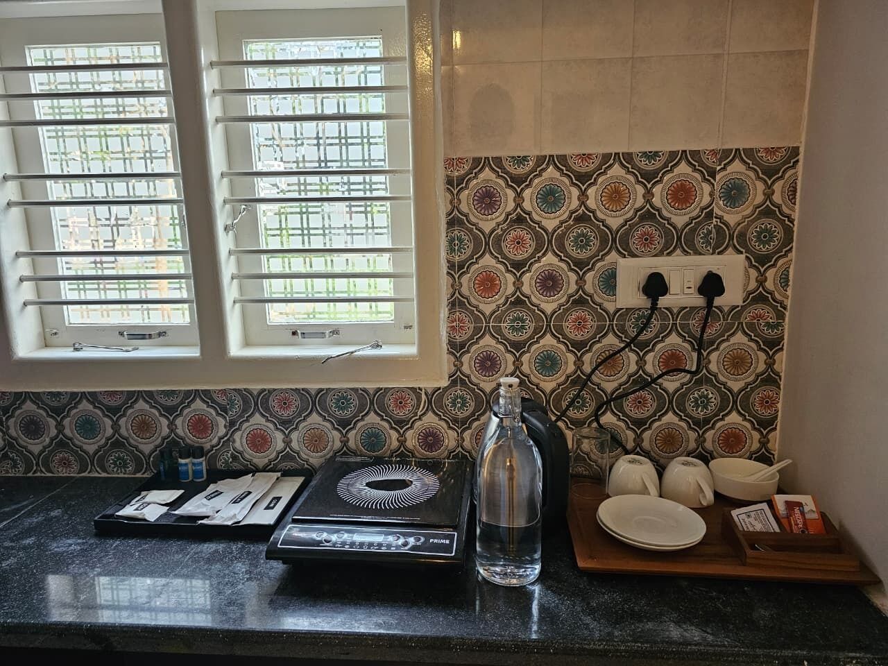 A kitchen with a gas stove, a bottle, and a tray with dishes.