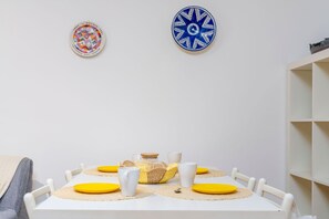 A dining table with yellow placemats, white plates, and a woven basket centerpiece. - Cozy and comfortable 50 square meters apartment, perfect for four people, located on the first floor of a building with an elevator (NOT accessible to disabled guests).The property is located in an extremely quiet area; its location allows our guests to  (Grado-Pineta)