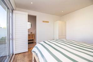 Une chambre à coucher comprenant un lit, une armoire, un miroir et une petite salle de bain.