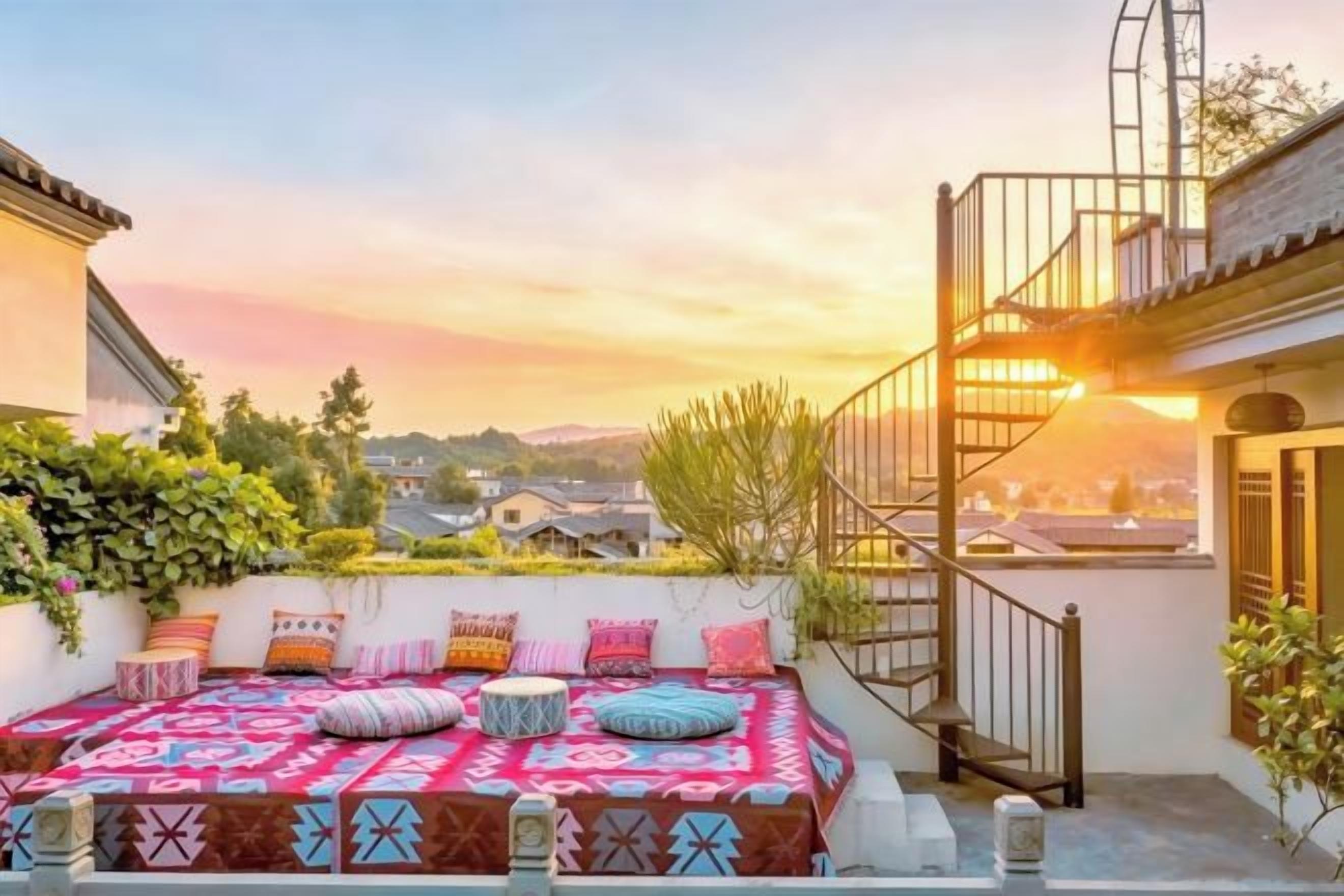 A rooftop terrace with a patterned outdoor seating area, a staircase, and a view of the cityscape.