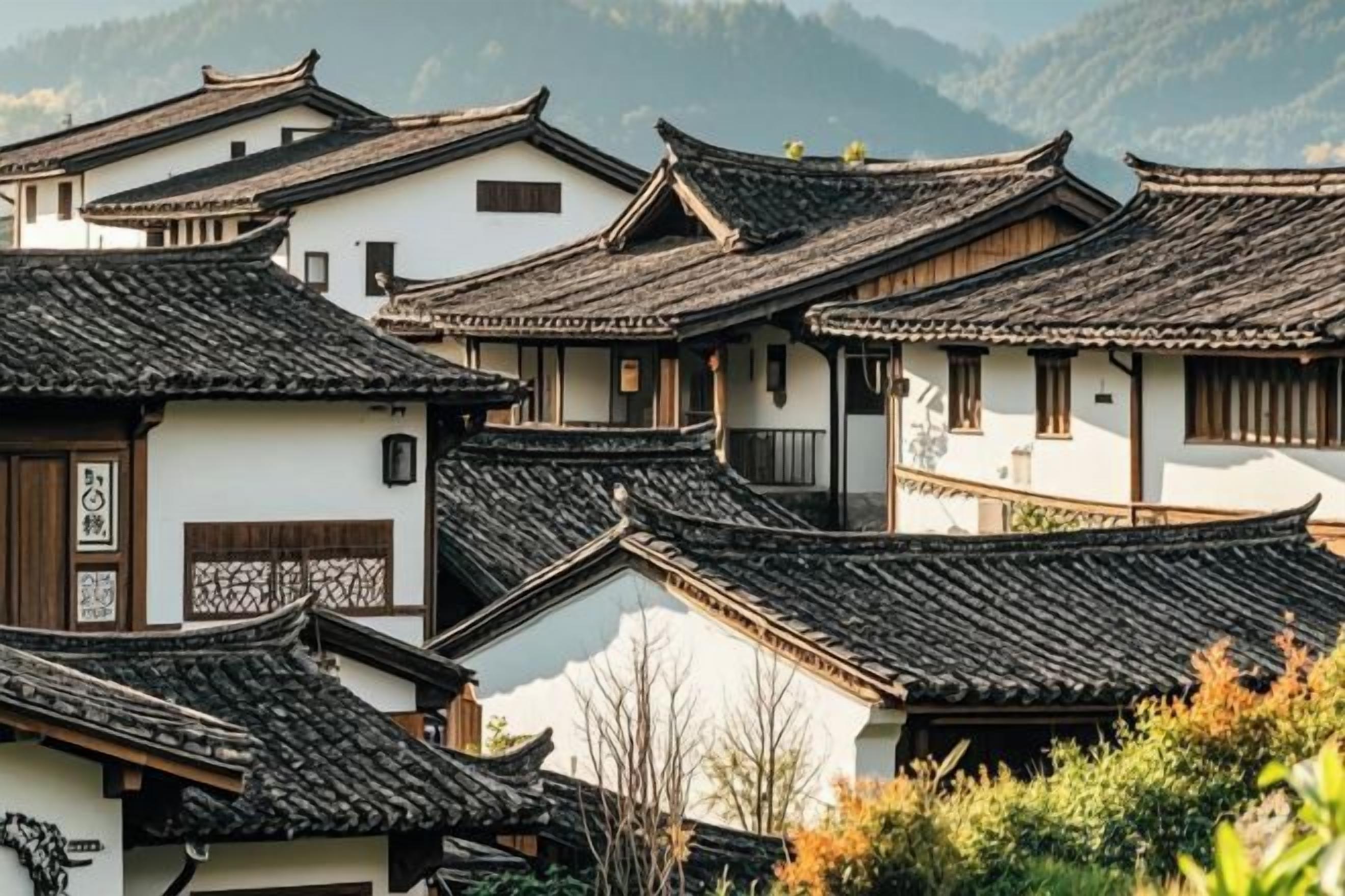 Traditional buildings with multiple roofs and a mountainous backdrop.