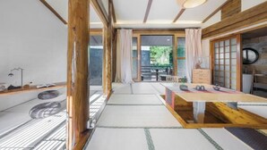 A traditional Japanese room with tatami flooring, a low wooden table, and sliding doors. - Yugui Hot Spring Holiday Hotel (Tengchong)