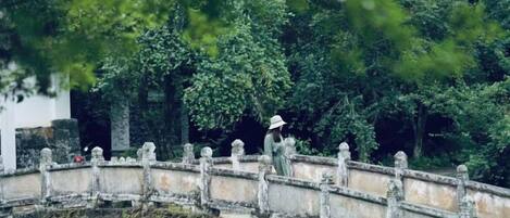 A stone bridge over a body of water with a person walking on it.