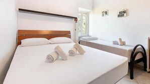 A hotel room with a large bed, a smaller bed, a bedside table, and a window. - Hostdomus - Oltrefinale (Liguria)